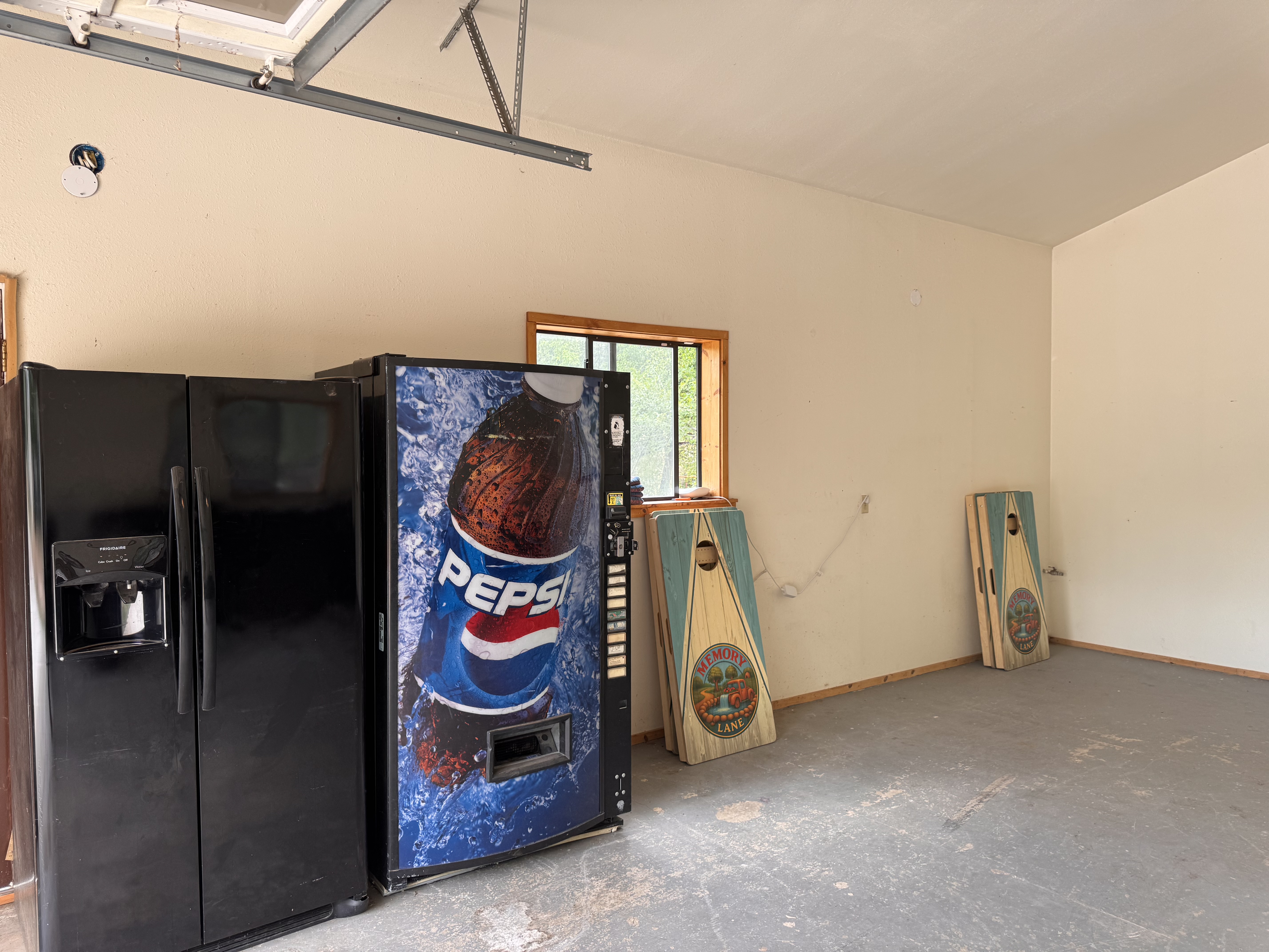 Warehouse interior with fridge, vending machine, and cornhole boards