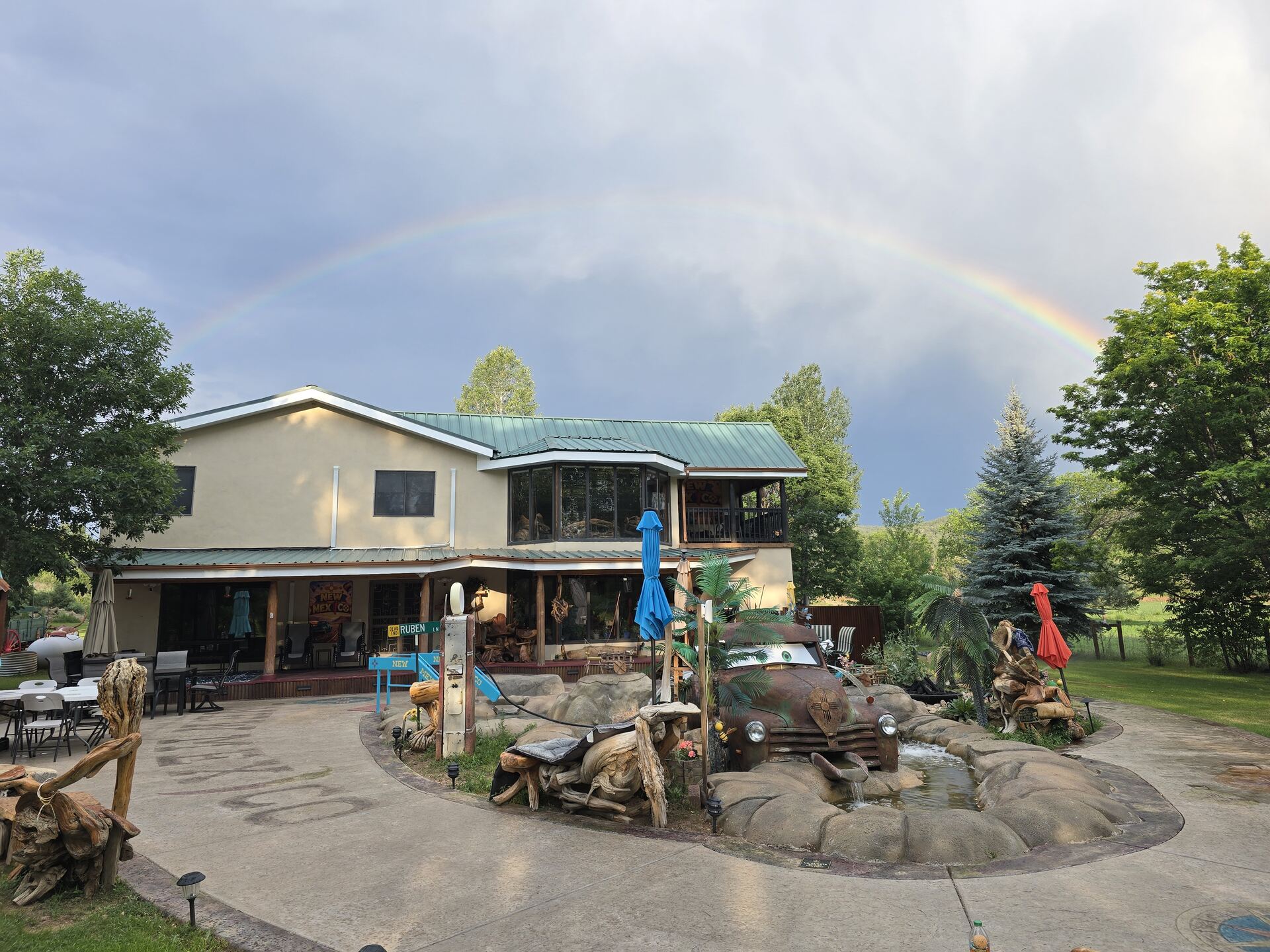 Memory Lane Estate main house with a rainbow overhead and the vintage truck fountain