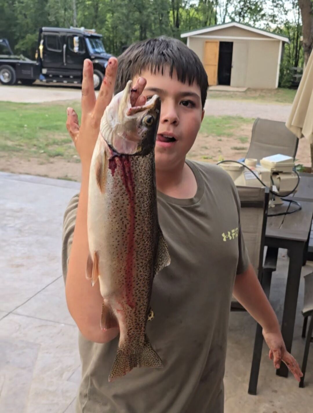 Guest holding a trout caught in the Pecos River behind Memory Lane Estate